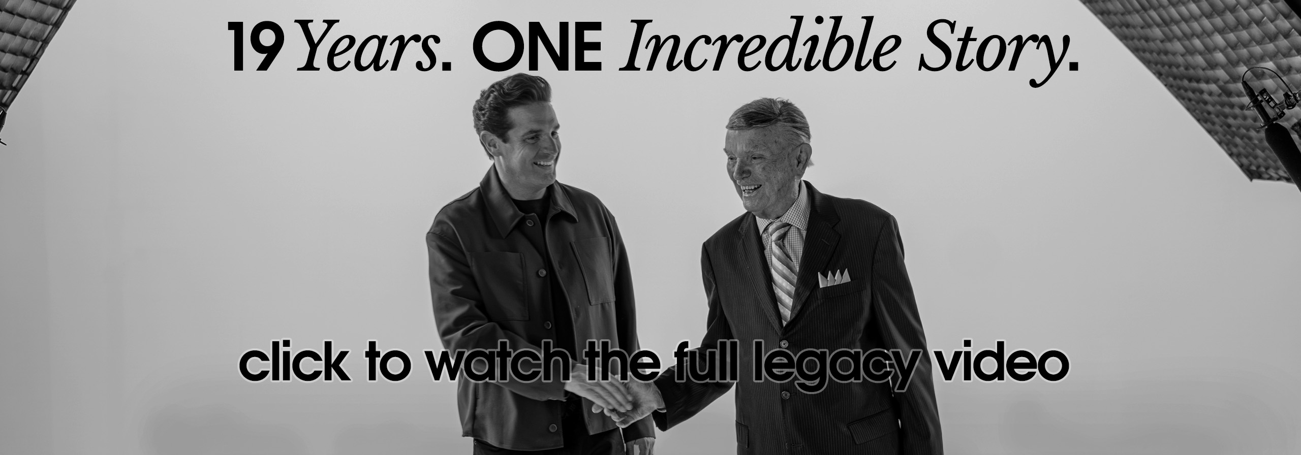 Two men shake hands in a studio, with bold banner text: '19 Years. ONE Incredible Story.' and 'click to watch the full legacy video'.